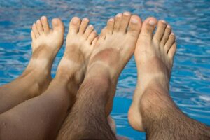 two pairs of bare feet showing tanning lines